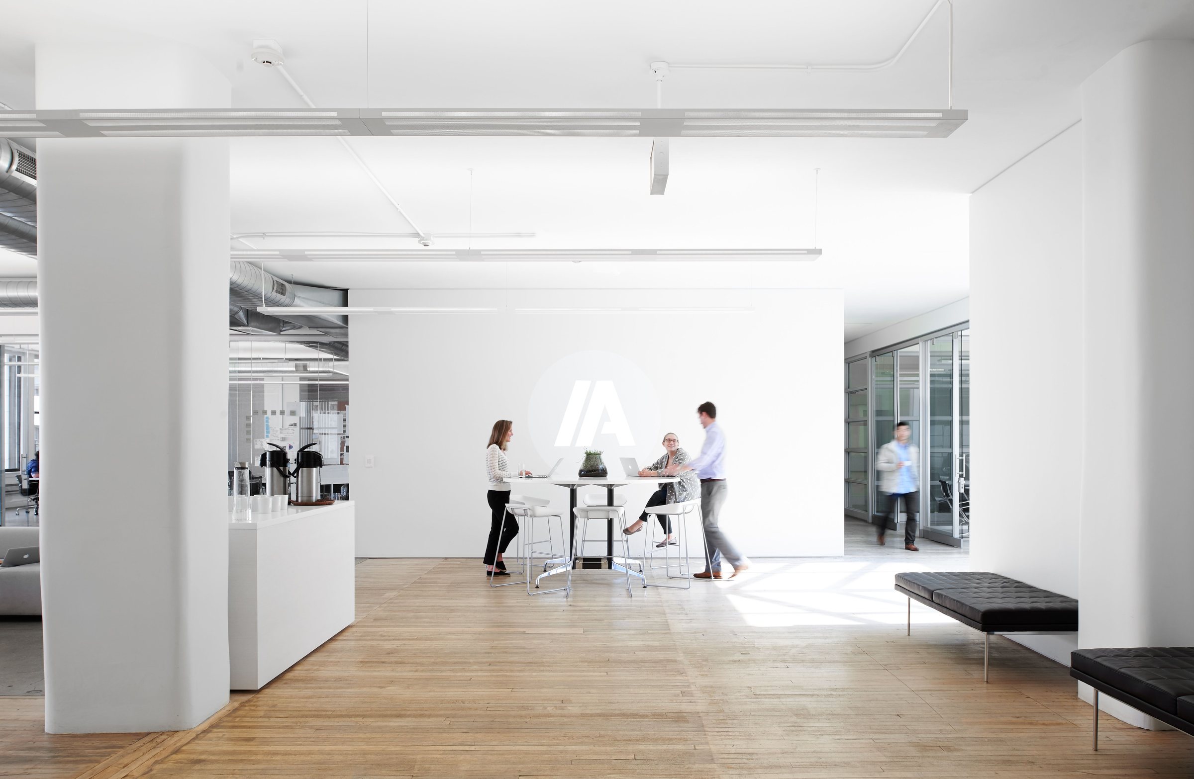 IA's open studio in natural light, with the IA mark on the far wall.